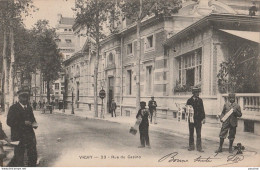 P17-03) VICHY -  RUE DU CASINO - (ANIMEE - MARCHANDS DE JOURNAUX ET CARTES POSTALES - 1905 - 2 SCANS) - Vichy