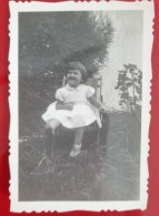 PH - Ph Petit Original - Petite Fille En Robe Blanche Assise Souriante Dans Le Jardin à La Maison - Personnes Anonymes