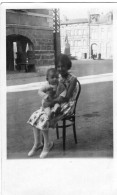 Grande Photo D'une Jeune Fille élégante Avec Un Petit Bébé Assis Sur Une Chaise Dans La Rue D'une Ville - Anonyme Personen