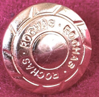 ETAT LUXE Pour Ce PIN'S "ROCHAS" Zamac Base Or Avec Pointe Dans Verso En Creux, Diamètre 1,7cm, Recto Bombé - Perfume