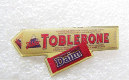 Delcampe - PIN'S    TOBLERONE  DAIM - Alimentación