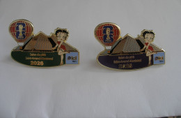 Delcampe - 2 Pin's Salon Du Pin's Saint Amand Montrond 2026, Betty Boop, Montgolfière FIFA Mondial Football 2026, Radio Ici Berry - Non Classés